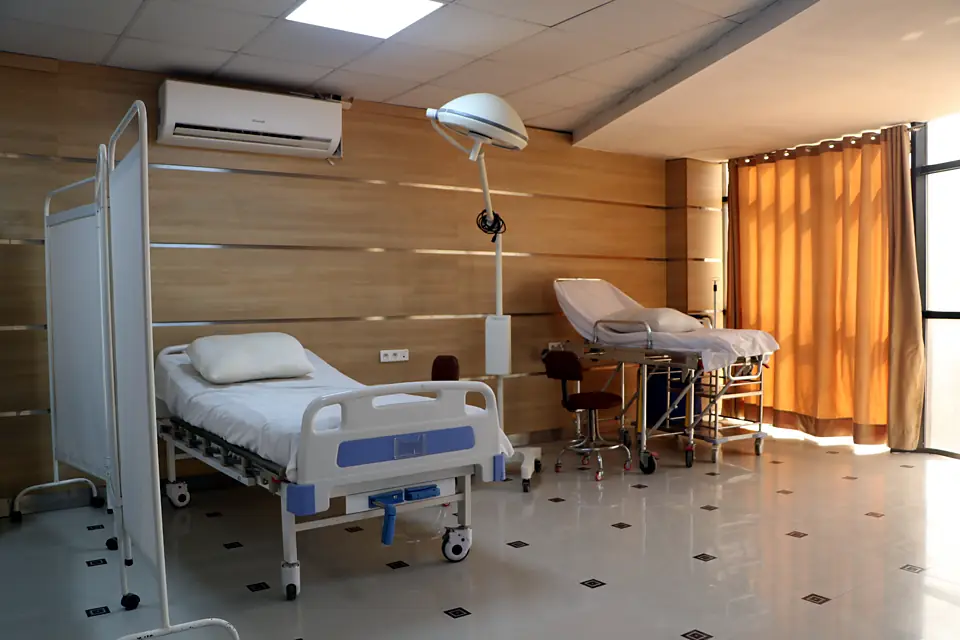 Salle de soins avec lit médicalisé, paravent et scialytique